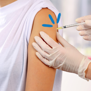 Image shows a close up of a person's arm getting a vaccine with a needle.