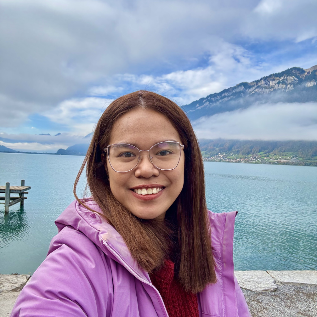 Dr Alma smiles at the camera. She has dark medium length hair and is wearing glasses